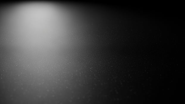 Black and white photo of a light shining on a dark background