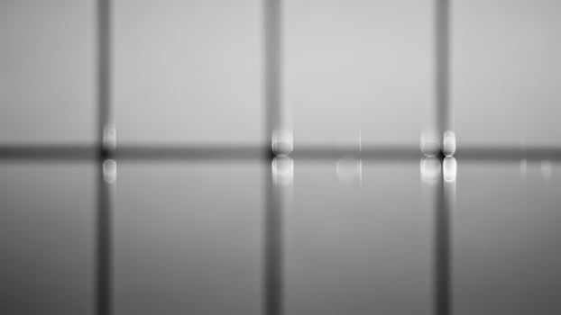 A black and white photo of a window with a light shining through