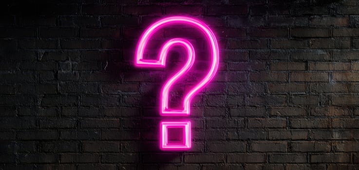 The Neon Question Sign Illuminating a Gritty Urban Brick Wall photo
