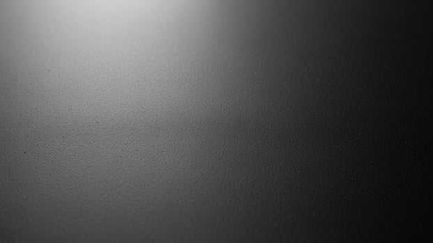 Black and white photo of a wall with a light shining on it