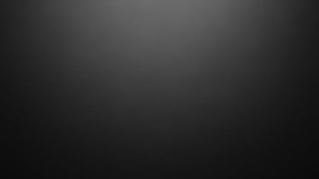 A black and white photo of a person standing in front of a black background