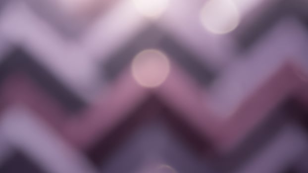 A purple and black chevron background with a light shining through photo