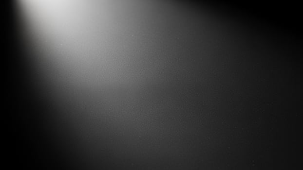 Black and white photo of a spotlight shining on a black background