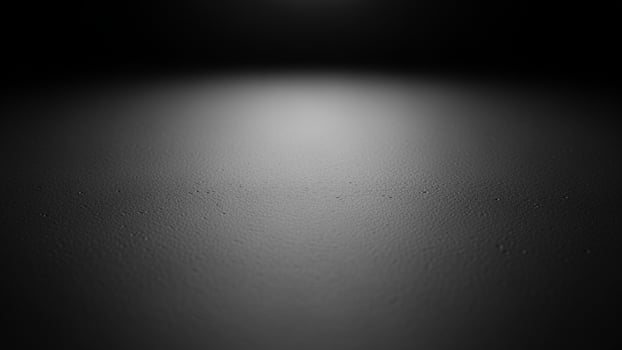 Black and white photo of a light shining on a dark surface