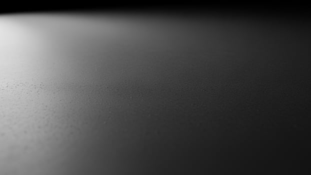 Black and white photo of a wall with light coming from the top