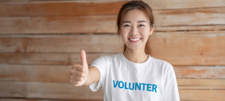 The smiling volunteer giving a thumbs-up for community engagement and support. photo