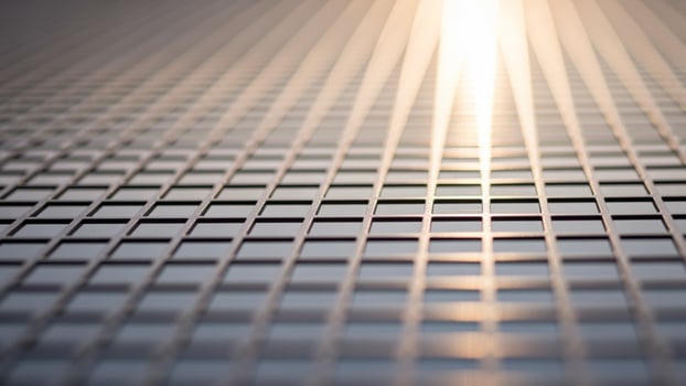 A close up of a metal grid with light shining through photo