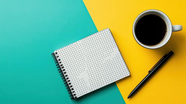 Open dotted notebook, black pen and black coffee cup are displayed on turquoise and yellow background photo