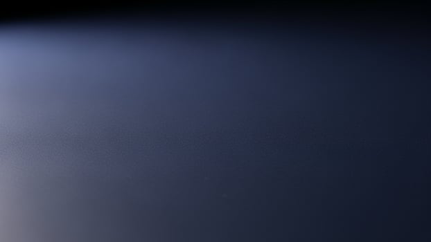 A close up of a black surface with a light shining through photo