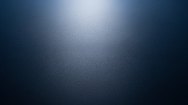 A dark blue background with light coming from the top photo