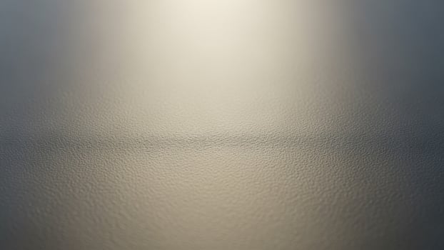 A close up of a shiny surface with light coming through photo