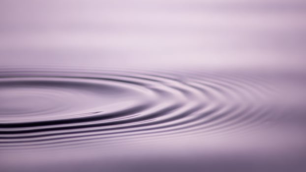A rippling wave on a purple surface photo