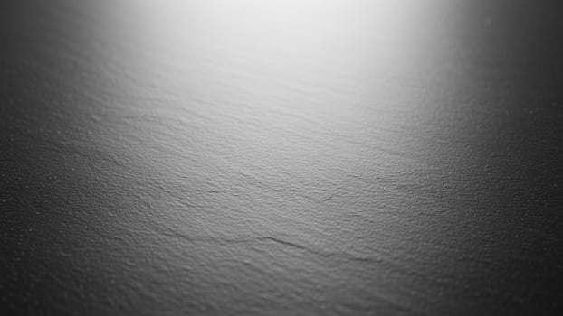 Black and white photo of a surface with light coming through