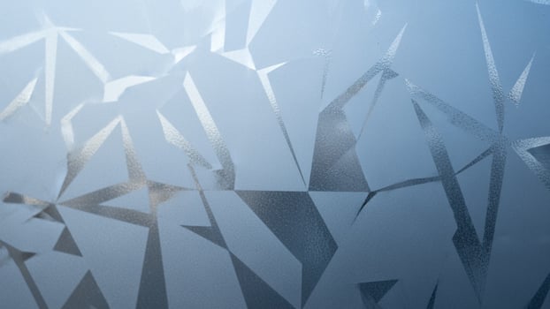 A close up of a frosted glass window with a blue sky photo