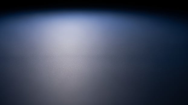 A dark blue background with a light shining on it photo