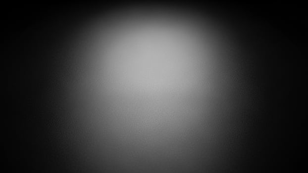 A black and white photo of a light in the dark background.