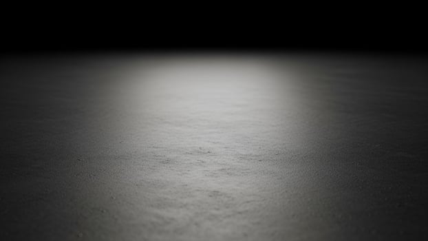 An empty black room with a light shining on it photo