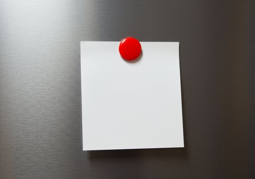 Blank note with red magnet on silver surface message template photo