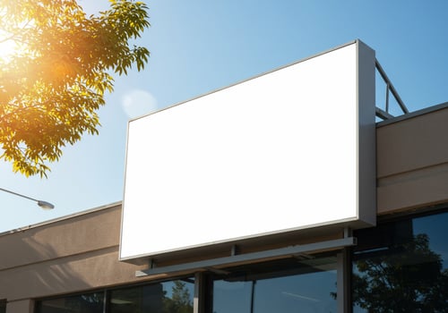 Blank outdoor billboard for advertising message on commercial building against clear blue sky offering copy space photo