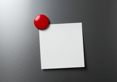Blank note paper with red magnet on metal background copy space photo