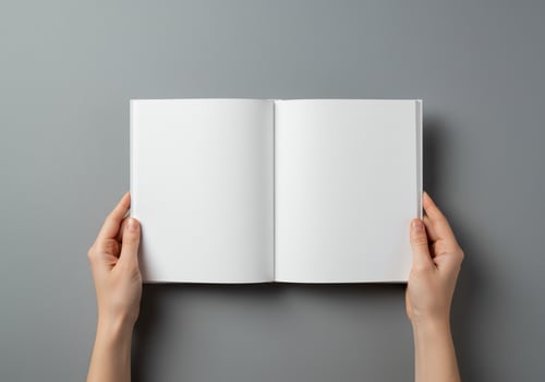 Open blank book held by hands on grey background for text and image layouts photo