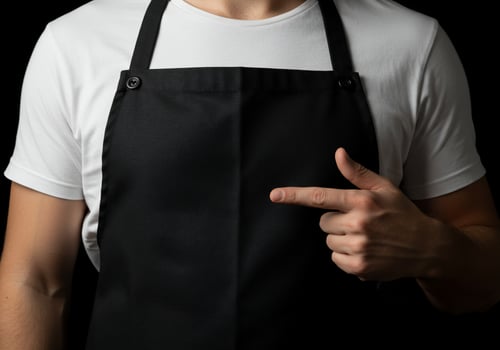 Person in apron pointing at center plain professional attire for cooking or serving photo