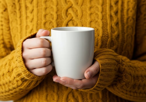 Person hold white mug in yellow sweater cozy comfort beverage photo