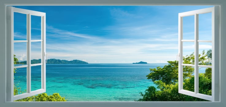 The picturesque ocean view through an open window overlooking a tranquil beach. photo