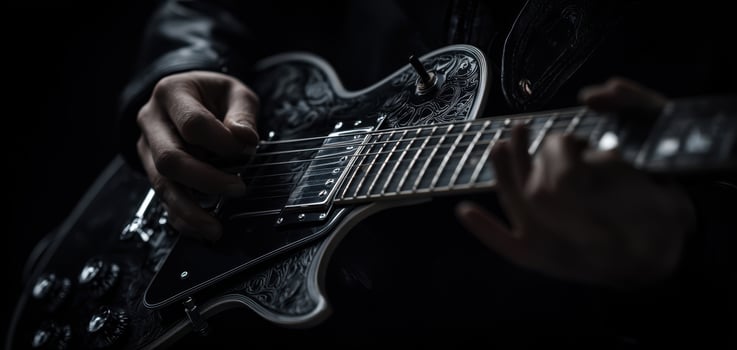 The electric guitar held by a skilled musician in dramatic lighting. photo