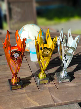 Three football tournament trophies on a wooden table photo