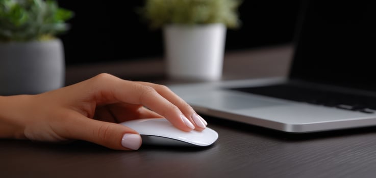 The interaction of a hand with a sleek computer mouse on a stylish desk. photo