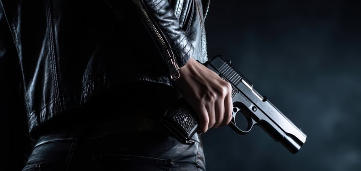 The Hand Holding a Gun in a Dark and Dramatic Setting photo