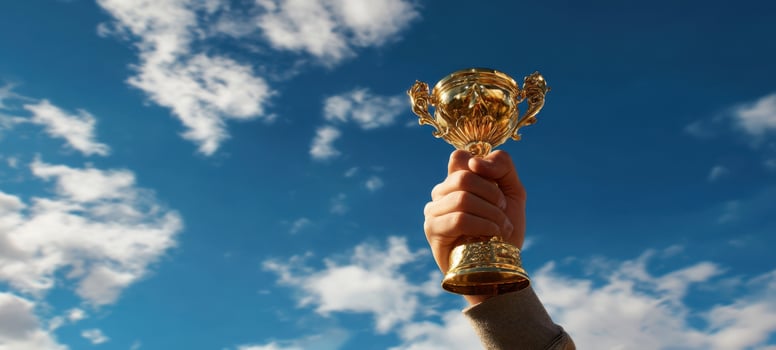 The trophy held high against a bright blue sky signifies victory and achievement. photo