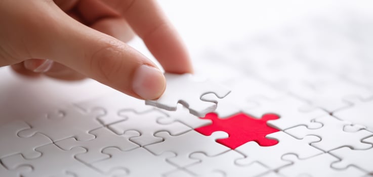 The hand placing a puzzle piece to complete the jigsaw. photo