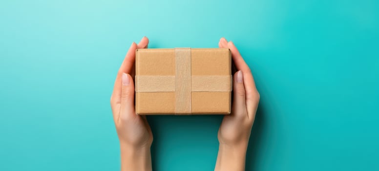 The hands holding a beautifully wrapped gift box on a vibrant background. photo