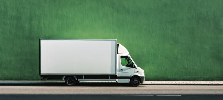 The white delivery truck parked against a vibrant green wall. photo