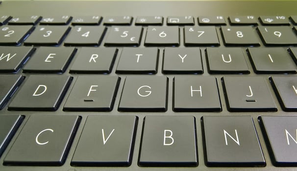 A close-up shot of a black keyboard on a laptop, showing the arrangement of the QWERTY keys. The image has a sharp focus on the keys, highlighting the letters and numbers. photo