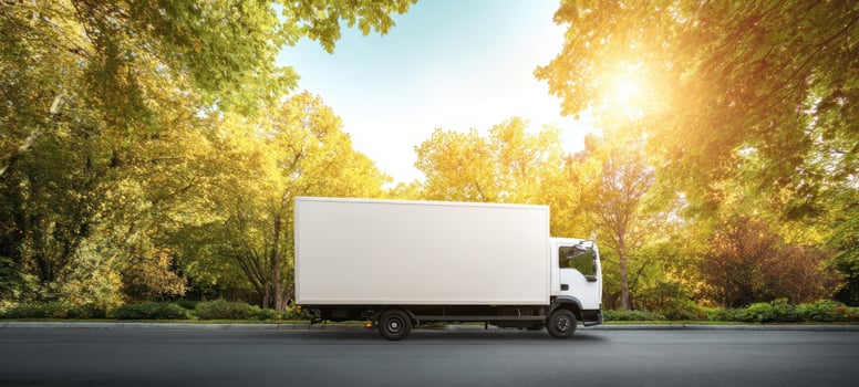 The white truck parked on a scenic road surrounded by vibrant trees. photo