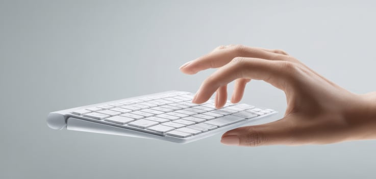 The hand gently hovering above a sleek, modern wireless keyboard. photo