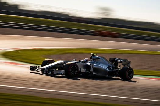 Silver Formula One Car Speeding on Racetrack with Motion Blur photo