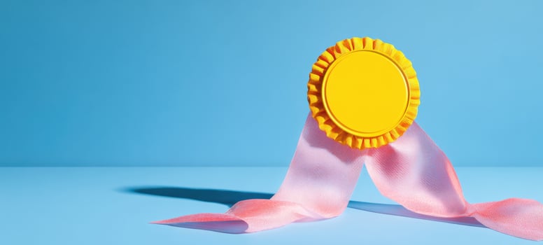 The Yellow Award Ribbon with Pink Streamers on a Bold Blue Background photo