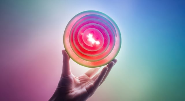 Hand holding a glowing, colorful crystal ball with swirling patterns photo