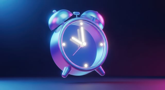 A vintage alarm clock glowing with neon blue and pink light photo