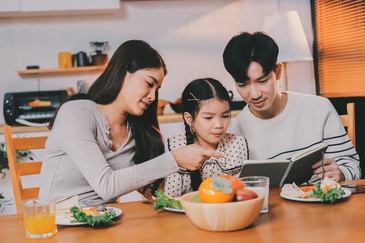 Family sharing a meal and reading together photo