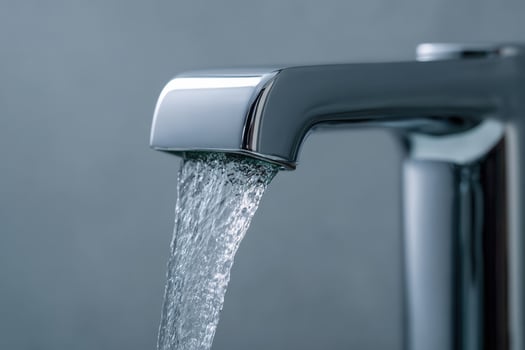 Elegant chrome waterfall tap delivering a steady stream of clear water in a modern bathroom setting photo