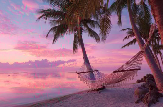 Hammock on the beach with palm trees at sunset photo
