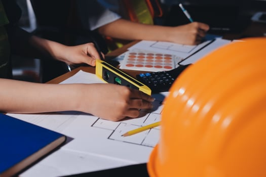 Hands measuring construction plans with tools photo