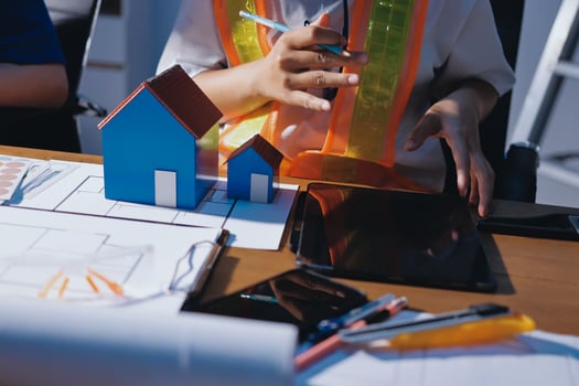Architect working with house models and tablet photo