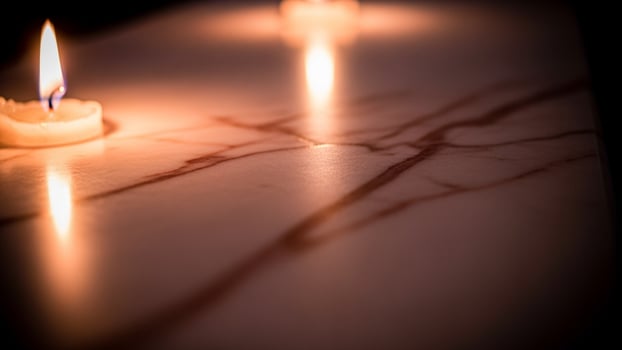 Three candles are lit on a marble table photo
