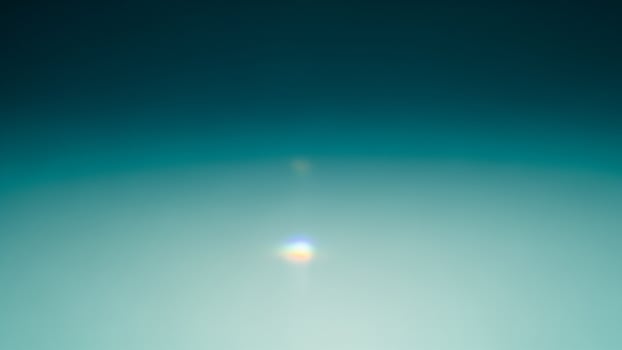 A bright light shining through a dark blue sky photo